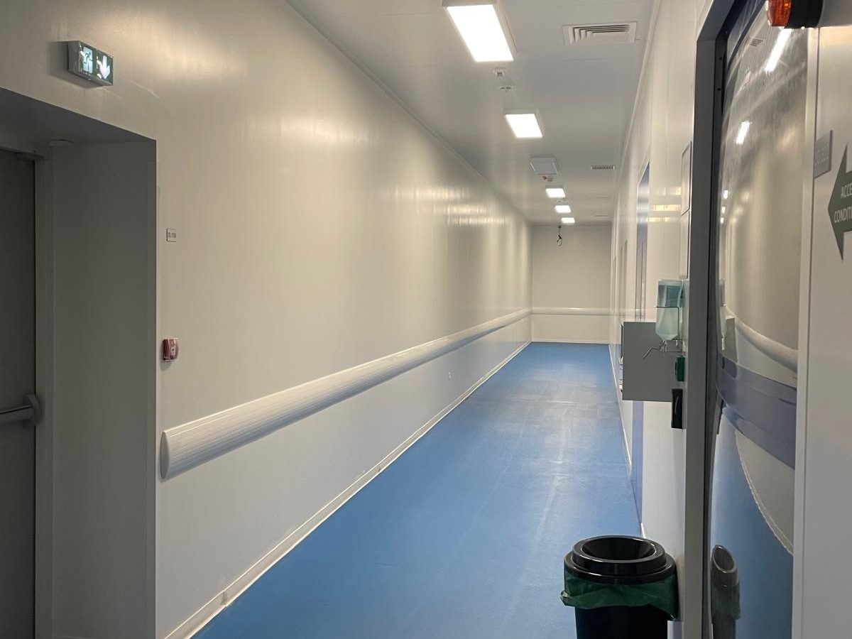 Couloir de laboratoire pharmaceutique : murs remis en peinture et pare-chocs de protection posé sur toute la longueur.