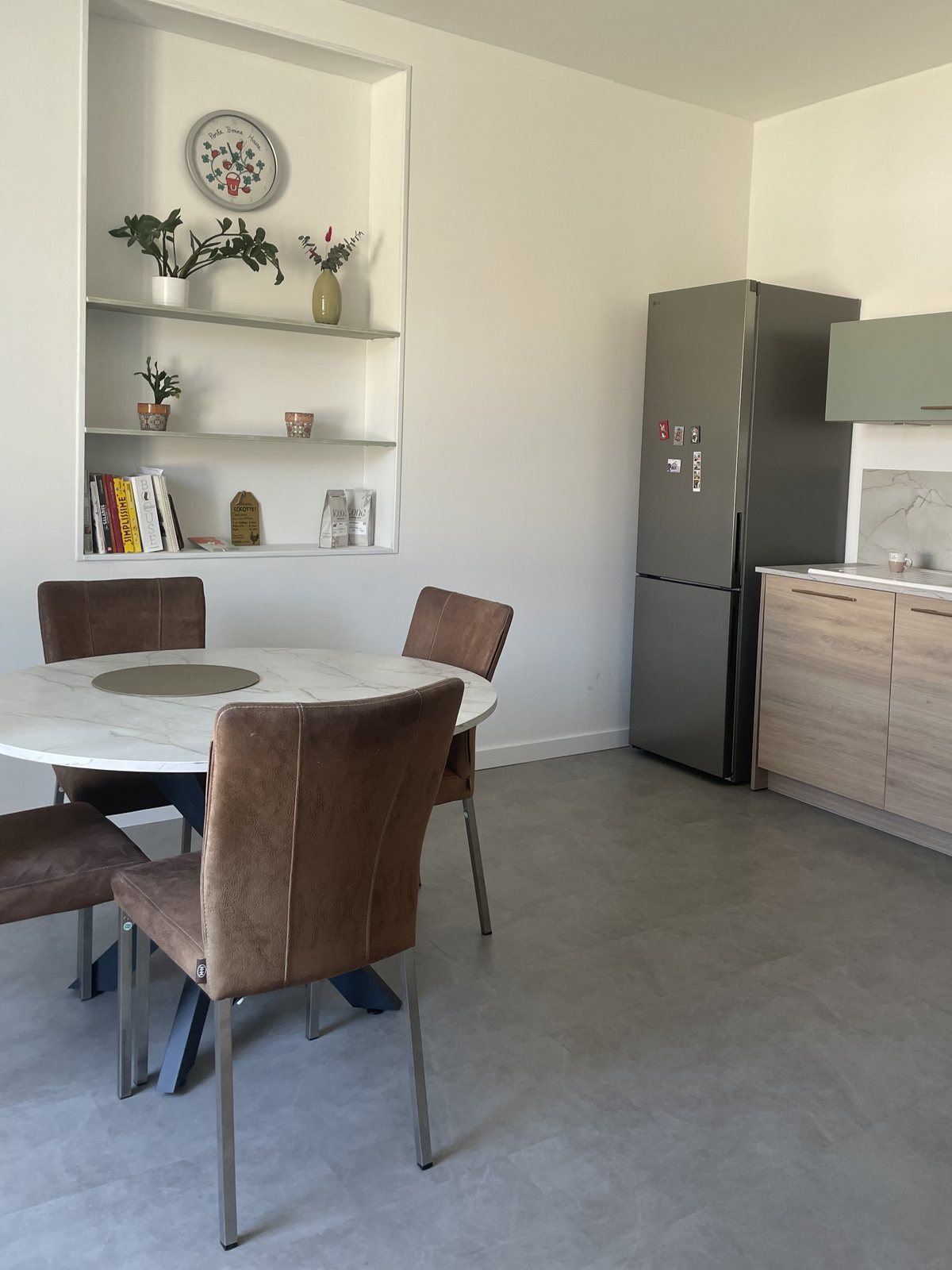 La même cuisine après travaux : murs peints, niche murale finie et équipée d'étagères, sol neuf posé.
